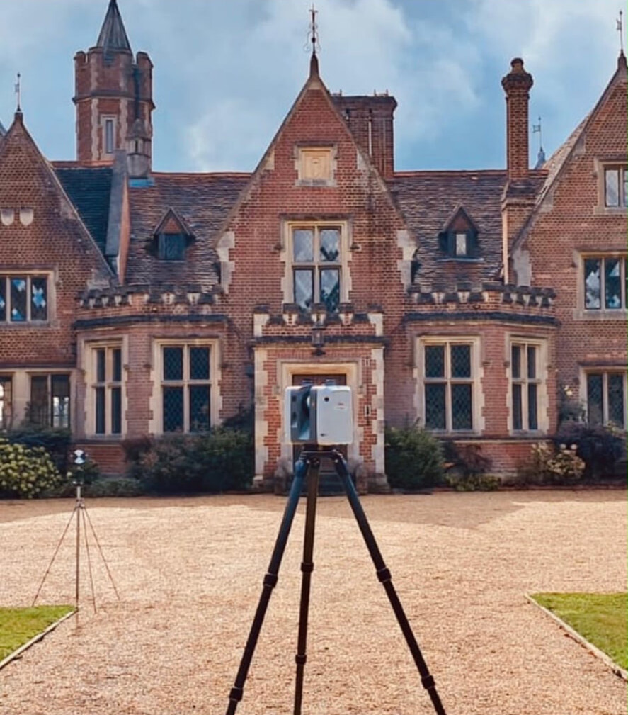 Laser scanner capturing a red-brick manor house